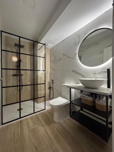 a bathroom with a sink and a toilet and a mirror at Apartamento Sol y Playa in Rota