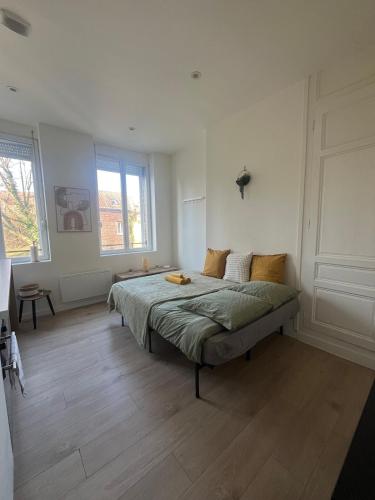 une chambre avec un lit au milieu d'une pièce dans l'établissement Le Rivage - Gare, Wifi, Parking, TV, à Douai