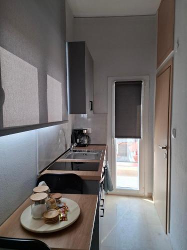 a kitchen with a sink and a table with a plate at Kozani room with a view! in Kozani