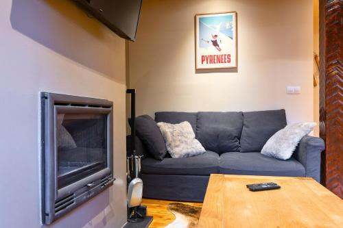 a living room with a blue couch and a tv at Rústico y Elegante I Estancia con Aparcamiento in El Tarter