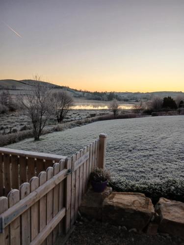 a fence in a field with snow on the ground at Ella Rose Mobile Home in Durnesh