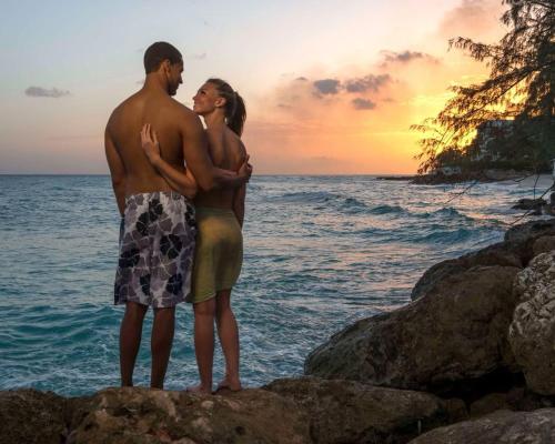a man and a woman standing on the rocks near the ocean at Eagle Stays Aruba-NEW Luxury, Cozy & Spacious Studio Near Eagle Beach! in Oranjestad