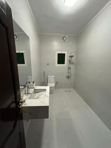 a white bathroom with a sink and a toilet at شقق الجود in Medina