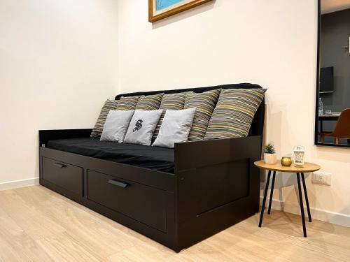 a black bed with pillows on it in a room at SILVIO'S Apartment in Castellammare del Golfo