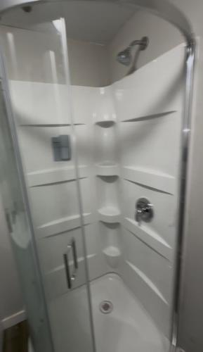 a bathroom with a glass shower with a sink at Our modern tiny home in Terre Haute