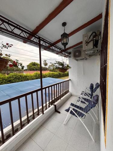 two chairs on a balcony with a view of the water at Jerusalén Hotel Boutique in Mariquita