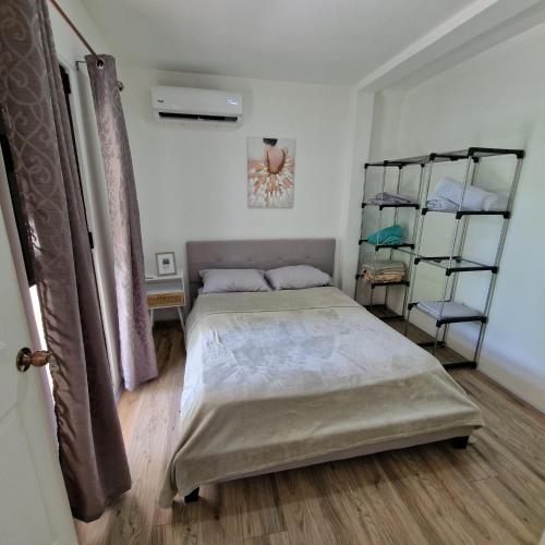 a bedroom with a bed and shelves in it at Cozy houses near a beach in Puntarenas