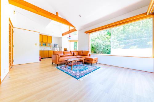 a living room with a couch and a table at コテージいっぺき湖 in Ito
