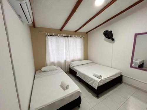 a room with two beds and a window at Jerusalén Hotel Boutique in Mariquita
