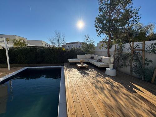 une cour avec une piscine, un canapé et une table dans l'établissement Villa d'architecte aux portes de la mer, à Pérols