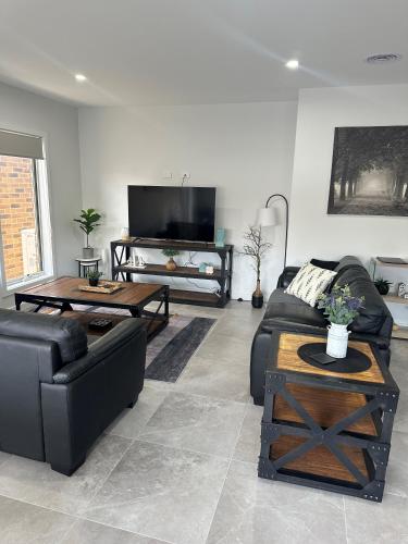a living room with a couch and a table at Lbarza New Exec 3BR Townhouse walk to shopping centre in Kialla