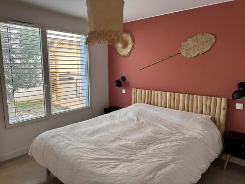 une chambre avec un lit et une horloge au mur dans l'établissement Villa d'architecte aux portes de la mer, à Pérols
