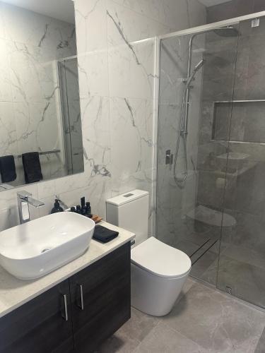 a bathroom with a toilet and a sink and a shower at Lbarza New Exec 3BR Townhouse walk to shopping centre in Kialla