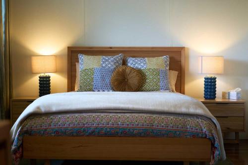 a bedroom with a large bed with two lamps at Rosecliffe Farm Cottages in Pomona