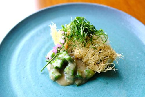 a blue plate of food with noodles and vegetables at Sankara Hotel & Spa Yakushima in Yakushima