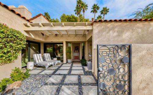 a home with a patio with chairs and a fence at Courtside Contemporary in Rancho Mirage