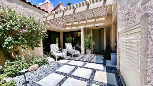 a patio with two chairs and a fence at Courtside Contemporary in Rancho Mirage