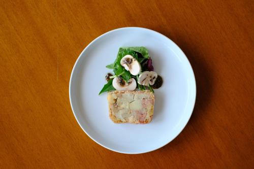 a white plate with a piece of food on a table at Sankara Hotel & Spa Yakushima in Yakushima