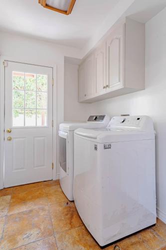 a kitchen with a washer and dryer next to a door at Cozy Home with Pool and Jacuzzi Minutes from Universal Studios in Los Angeles