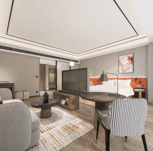 a living room with a bed and a table and chairs at Hilton Garden Inn Suzhou Kunshan in Suzhou