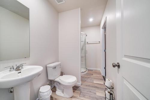 a white bathroom with a toilet and a sink at Spacious Home 8 Mi to Bernheim Arboretum! in Shepherdsville