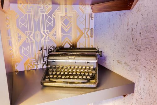 an old typewriter sitting on a shelf in a room at The Salome - ADA Accessible at The Louie Boutique Motel, Walk to Everything! Dog Friendly! in Newport