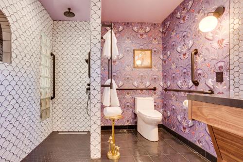a bathroom with a toilet and purple wallpaper at The Salome - ADA Accessible at The Louie Boutique Motel, Walk to Everything! Dog Friendly! in Newport
