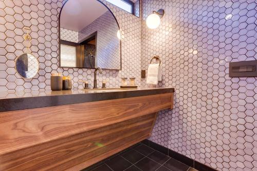 a bathroom with a sink and a mirror at The Salome - ADA Accessible at The Louie Boutique Motel, Walk to Everything! Dog Friendly! in Newport