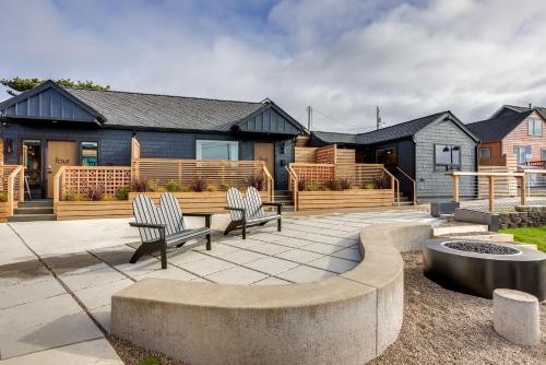 a patio with two chairs and a fire pit in front of a house at The Salome - ADA Accessible at The Louie Boutique Motel, Walk to Everything! Dog Friendly! in Newport
