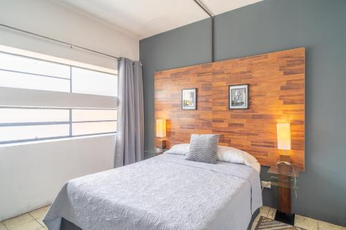 a bedroom with a bed and a wooden wall at Apart-Hotel "El Lago" in Guatemala