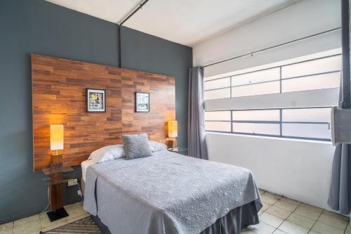 a bedroom with a bed and a large window at Apart-Hotel "El Lago" in Guatemala