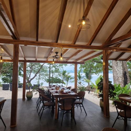 an outdoor dining room with a table and chairs at Cozy houses near a beach in Puntarenas
