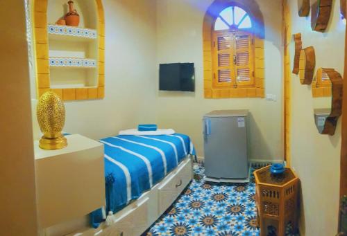 a bedroom with a bed and a small window at Dar Milal in Essaouira