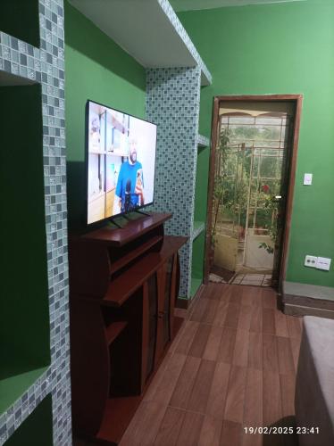 a living room with a tv on a wooden table at Recanto do Guerreiro in Anchieta