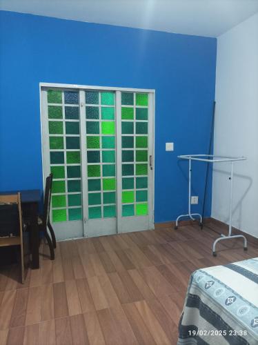 a bedroom with a blue wall and a door with a window at Recanto do Guerreiro in Anchieta