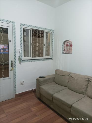 a living room with a couch and a window at Recanto do Guerreiro in Anchieta