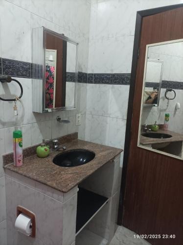 a bathroom with a sink and a mirror at Recanto do Guerreiro in Anchieta