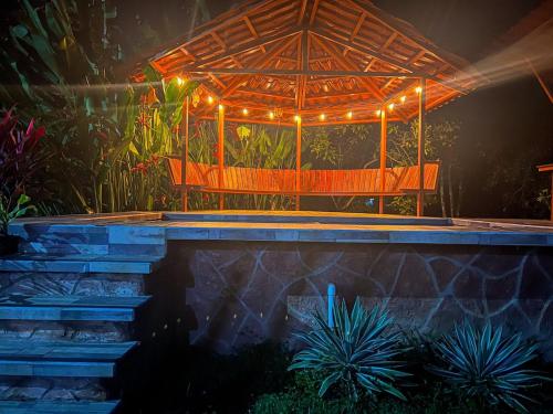 a patio with a bench with lights on it at La Casa de Piedra in Puerto Jiménez