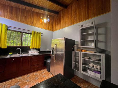 a kitchen with a stainless steel refrigerator and a sink at La Casa de Piedra in Puerto Jiménez