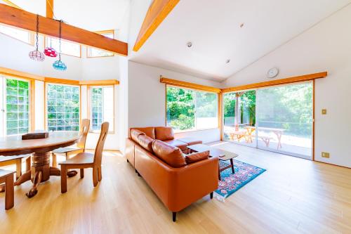 a living room with a couch and a table at コテージいっぺき湖 in Ito