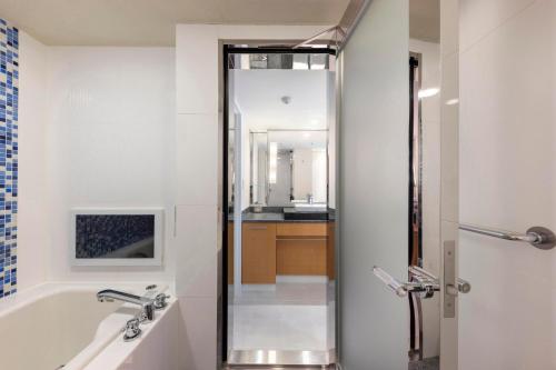 a bathroom with a bath tub and a shower at RIHGA Royal Hotel Osaka, Vignette Collection by IHG in Osaka