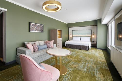 a hotel room with a bed and a couch at RIHGA Royal Hotel Osaka, Vignette Collection by IHG in Osaka