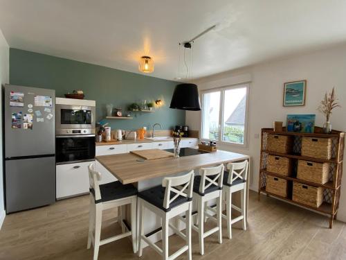 La cuisine est équipée d'une table, de chaises et d'un réfrigérateur. dans l'établissement Holiday Home in France with Sea View Terrace, à Saint-Gildas-de-Rhuys