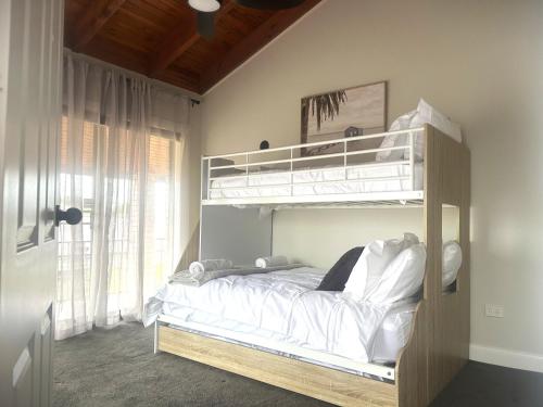 a bedroom with a bunk bed with white sheets at The Grand on Macquarie in Dubbo