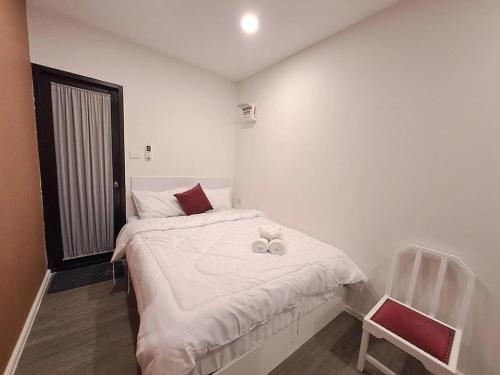 a small bedroom with a bed and a chair at Nomads Homestay Sriracha in Chon Buri