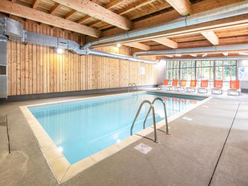 - une grande piscine dans un bâtiment aux murs en bois dans l'établissement 2 Room Apartment 5 People 1 Baby Garden Level, à Saint-Léger-les-Mélèzes