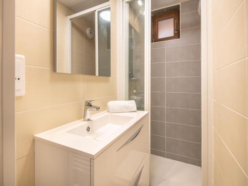une salle de bain blanche avec un lavabo et une douche dans l'établissement 2 Room Apartment 5 People 1 Baby Garden Level, à Saint-Léger-les-Mélèzes