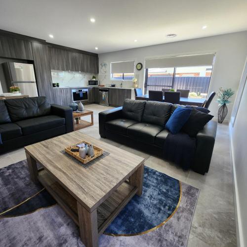 a living room with a couch and a coffee table at Lbarza Elegant Family 3BR Townhouse close to shopping centre Kialla in Kialla