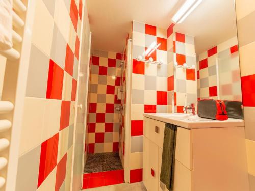 La salle de bains est pourvue d'un mur en damier rouge et blanc. dans l'établissement Gîte in Collonges near Dordogne Valley, à Meyssac