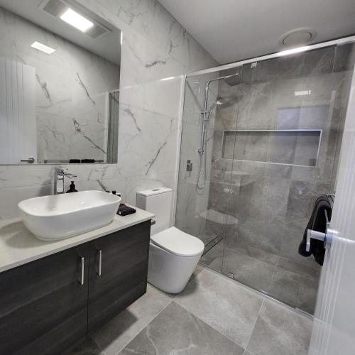 a bathroom with a shower and a sink and a toilet at Lbarza Elegant Family 3BR Townhouse close to shopping centre Kialla in Kialla